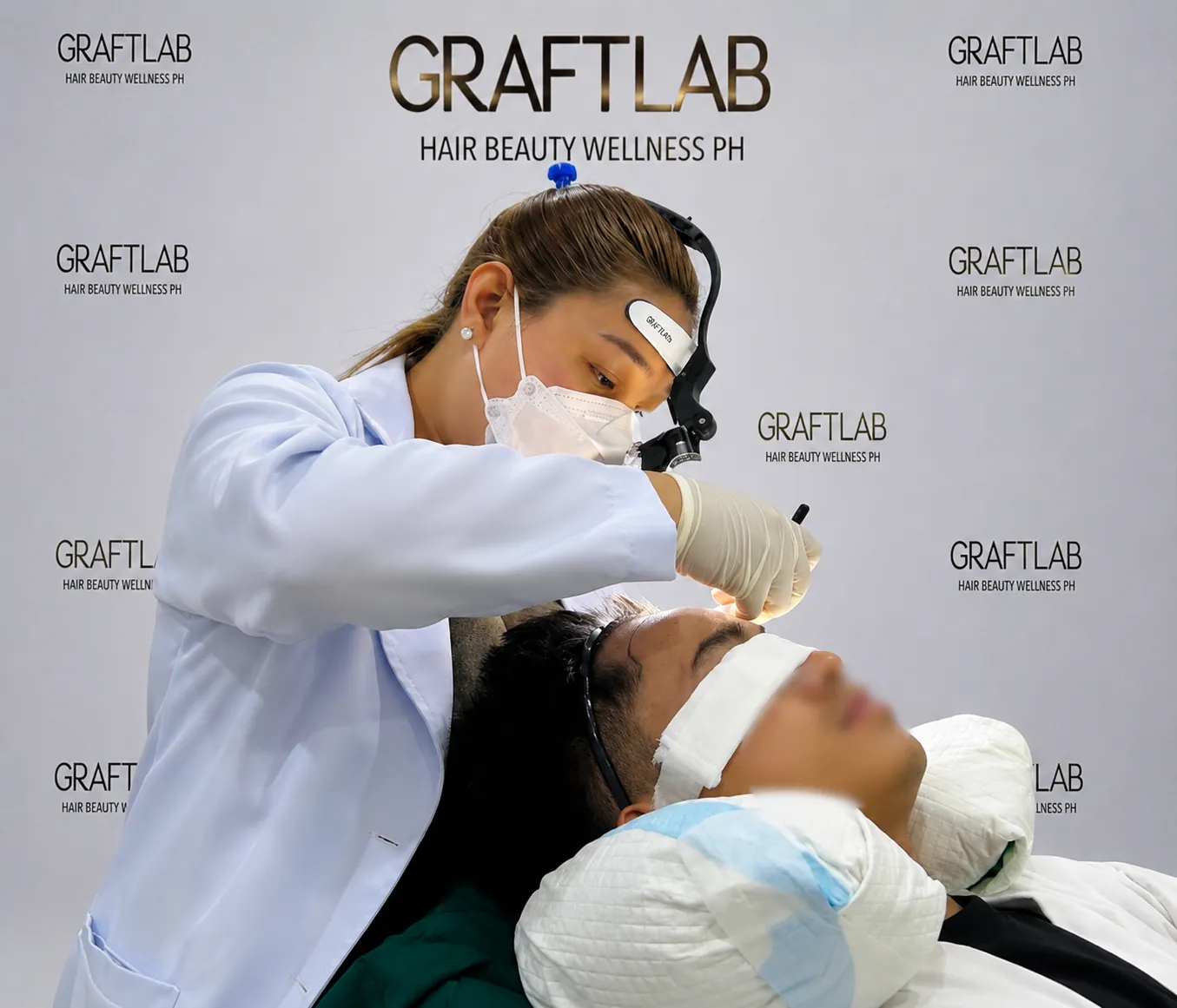GraftLab surgeon in loupes creating recipient sites by hand along the patient's hairline